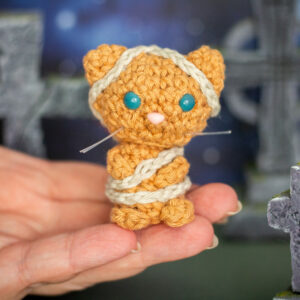 Amigurumi, figurines en crochet représentant un chat momie, tenu en main imaginé et confectionné à la main par les Mignonstres, une marque le Rat et l’Ours.