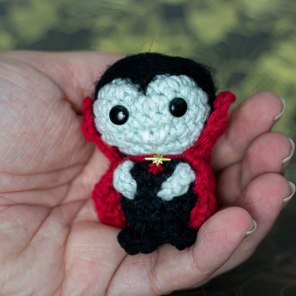 Amigurumi, figurines en crochet dans une main représentant Dracula le vampire, imaginé et confectionné à la main par les Mignonstres, une marque le Rat et l’Ours.