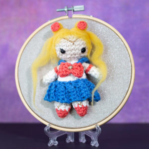 Tableau avec un amigurumi, figurine en crochet, représentant Sailor moon, guerrière de la lune, créée et réalisée par le Rat et l'Ours.