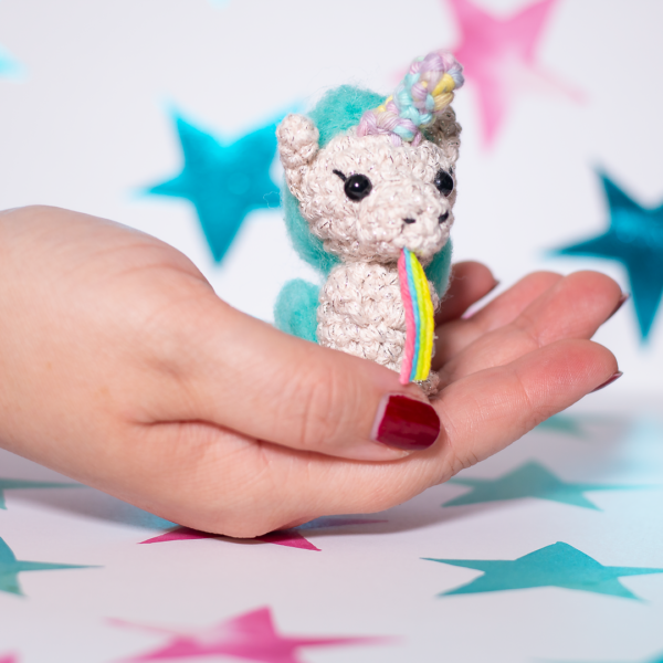 Amigurumi, figurines en crochet représentant Starlette la licorne bleue, tenue en main imaginée et confectionnée à la main par les Mignonstres, une marque le Rat et l’Ours.