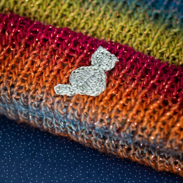 Detail en crochet, d'un bonnet fait main, representant un chat, confectionné par le rat et l'ours