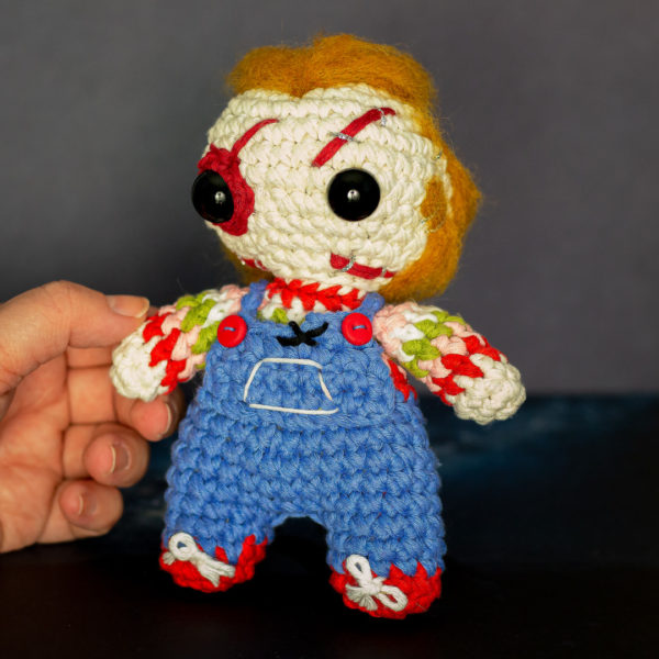 Amigurumi, figurine en crochet représentant Chucky, tenu en main imaginé et confectionné à la main par les Mignonstres, une marque le Rat et l’Ours.