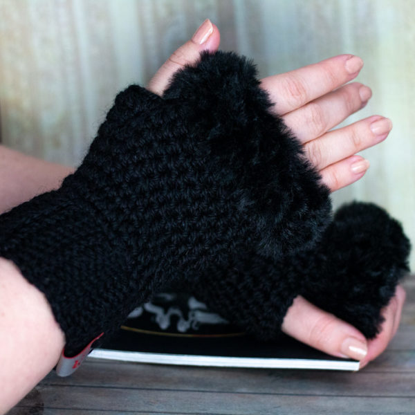 Mitaines en crochet, noires portées par une femme imaginées et confectionnées à la main par les Mignonstres, une marque le Rat et l’Ours.
