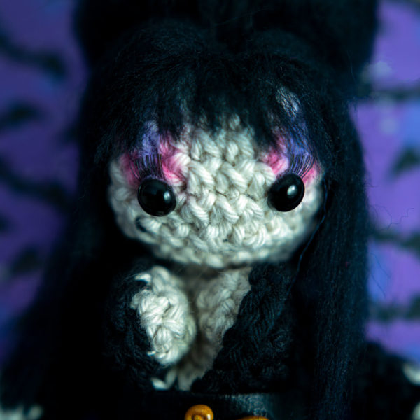 Tableau avec un amigurumi, figurine en crochet, représentant Elvira, maitresse des ténèbres, imaginé et confectionné à la main par le Rat et l'Ours.