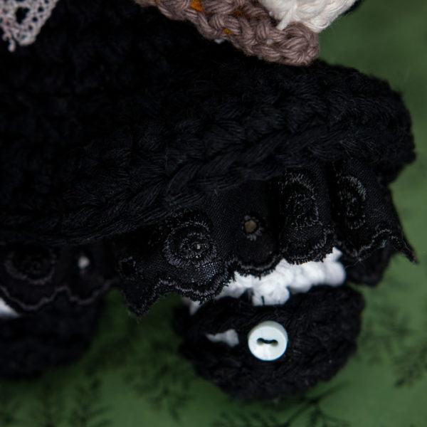 Détail d'un amigurumi, figurine en crochet représentant Martha une petite fille au masque de lapin, imaginée et confectionnée à la main par les Mignonstres, une marque le Rat et l’Ours.