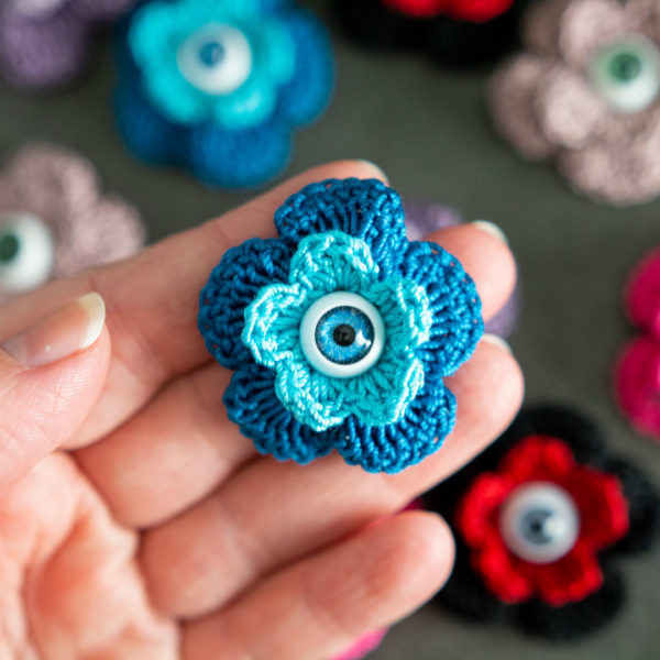 Broches en forme de fleur bleue (pivoine) avec un oeil au centre, imaginée et confectionnée à la main par les Mignonstres, une marque le Rat et l’Ours.