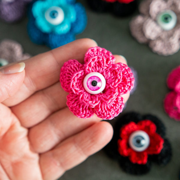 Broches en forme de fleur rose (pivoine) avec un oeil au centre, imaginée et confectionnée à la main par les Mignonstres, une marque le Rat et l’Ours.