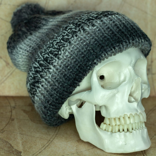 Bonnet gris en tricot, porté par un squelettes, imaginé et confectionné à la main par les Mignonstres, une marque le Rat et l’Ours.