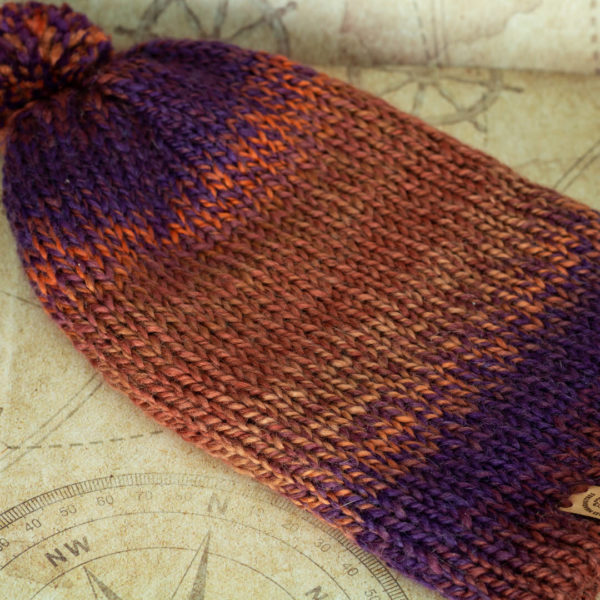 Bonnet violet et orange en tricot, à plat imaginé et confectionné à la main par les Mignonstres, une marque le Rat et l’Ours.