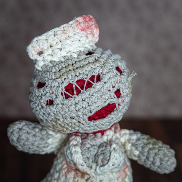 Détail du visage d'un amigurumi, figurine en crochet représentant une infirmière (nurse) du jeu vidéo Silent Hill, imaginée et confectionnée à la main par les Mignonstres, une marque le Rat et l’Ours.