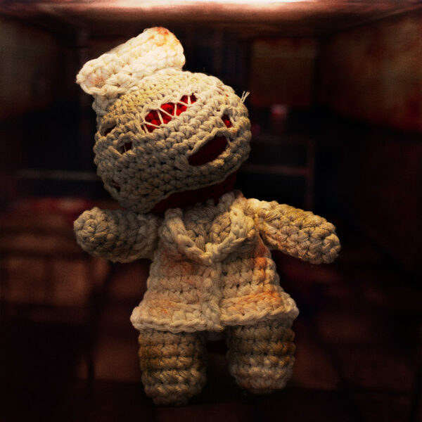 Amigurumi, figurine en crochet représentant une infirmière (nurse) du jeu vidéo Silent Hill, sur une photographie horrifique, imaginée et confectionnée à la main par les Mignonstres, une marque le Rat et l’Ours.