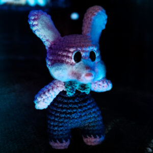 Photographie d'un amigurumi en crochet représentant Robbie le lapin, issu de la sage de jeu vidéo Silent Hill, imaginé et confectionné à la main par les Mignonstres, une marque le Rat et l’Ours.