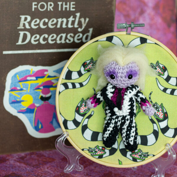 Tableau avec un amigurumi, figurine en crochet, représentant Beetlejuice, avec son look du dessin animé des années 90, imaginé et confectionné à la main par le Rat et l'Ours.