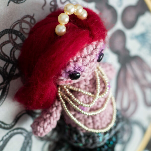Tableau avec un amigurumi, figurine en crochet, représentant les détails d'une sirène, créée et réalisée par le Rat et l'Ours.