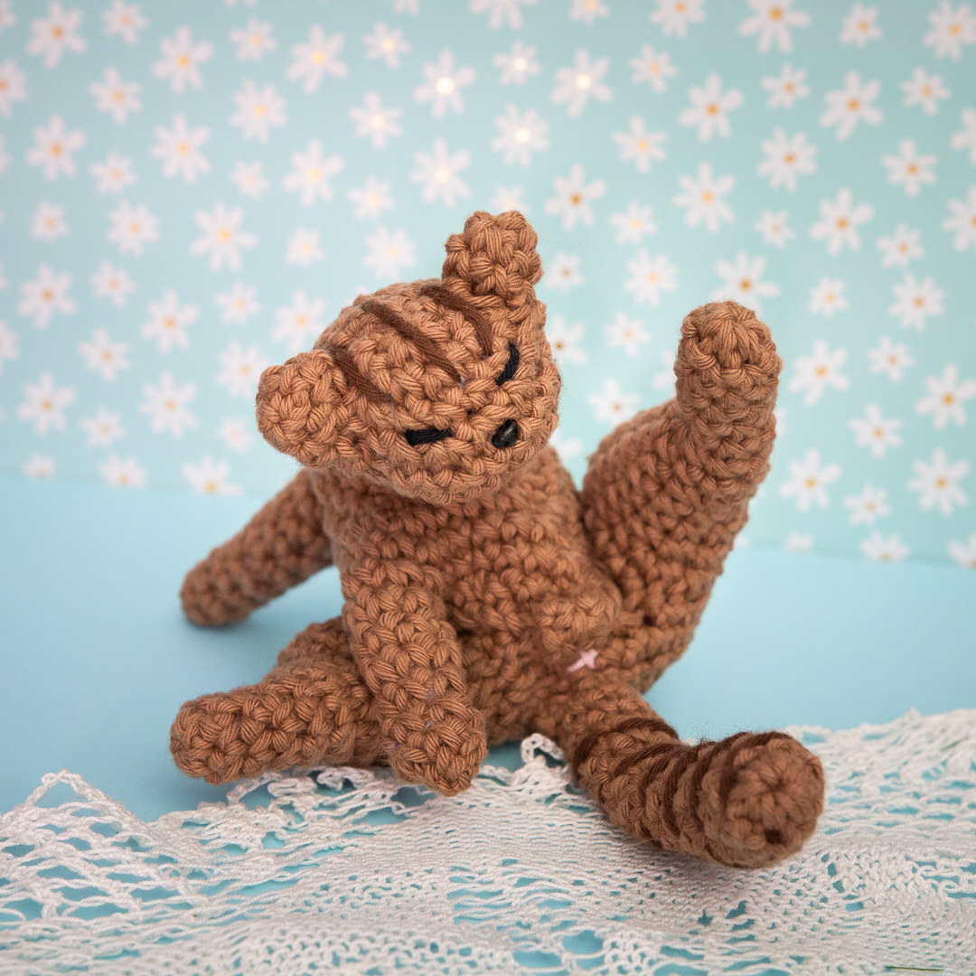 Amigurumi, figurine en crochet représentant un chat en pleine séance de toilette. Figurine imaginée et confectionnée à la main par les Mignonstres, une marque le Rat et l’Ours.