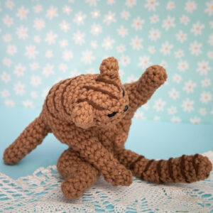 Amigurumi, figurine en crochet représentant un chat en pleine séance de toilette. Figurine imaginée et confectionnée à la main par les Mignonstres, une marque le Rat et l’Ours.