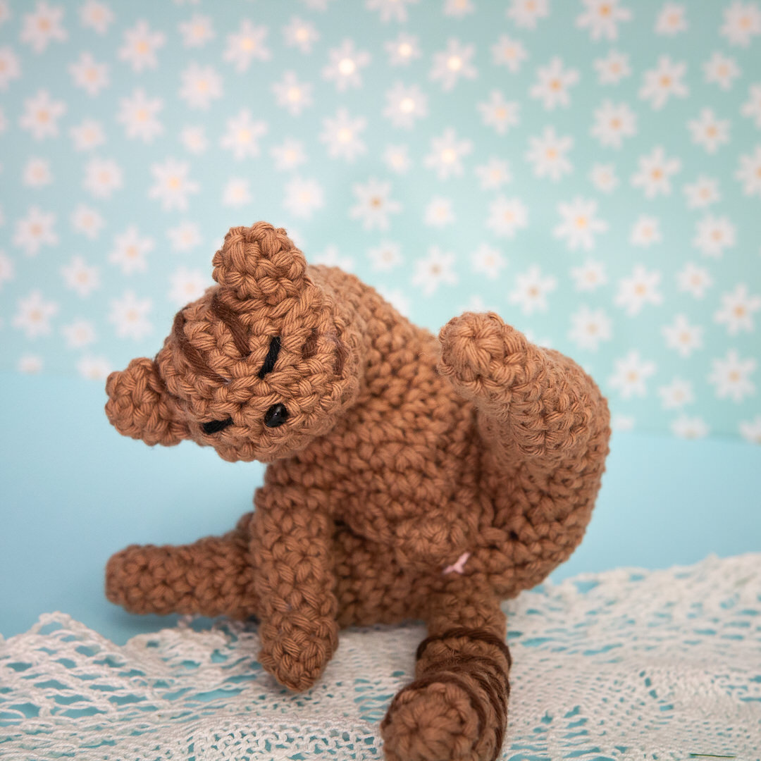 Amigurumi, figurine en crochet représentant un chat en pleine séance de toilette. Figurine imaginée et confectionnée à la main par les Mignonstres, une marque le Rat et l’Ours.