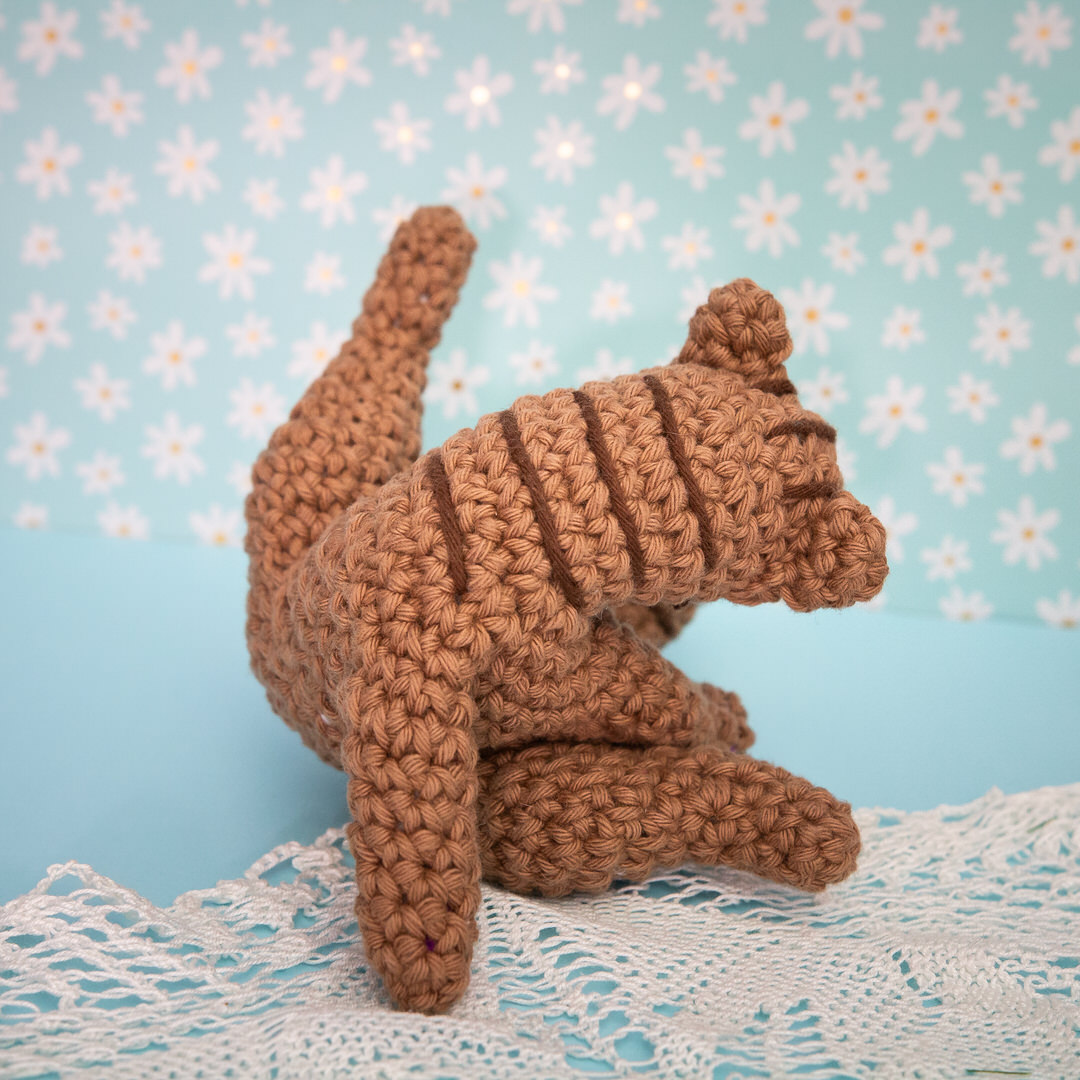 Amigurumi, figurine en crochet représentant un chat en pleine séance de toilette. Figurine imaginée et confectionnée à la main par les Mignonstres, une marque le Rat et l’Ours.