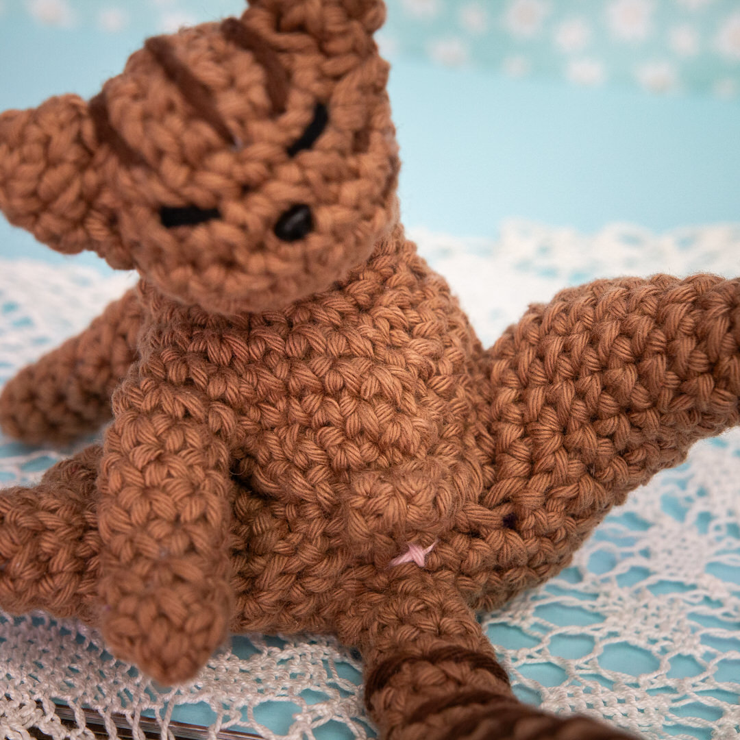 Amigurumi, figurine en crochet représentant un chat en pleine séance de toilette. Figurine imaginée et confectionnée à la main par les Mignonstres, une marque le Rat et l’Ours.