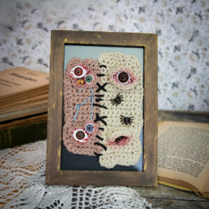 Tableau en crochet sur le thème du body horror, avec deux peaux différentes cousues ensemble, et des araignées qui se promènent dessus… Œuvre imaginée et confectionnée à la main par les Mignonstres, une marque le Rat et l’Ours.